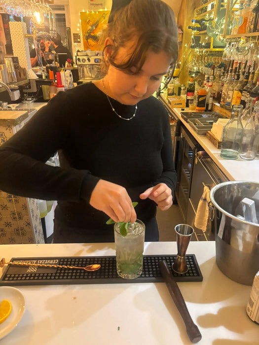 Alessia garnishing and serving a cocktail in the beginners course.